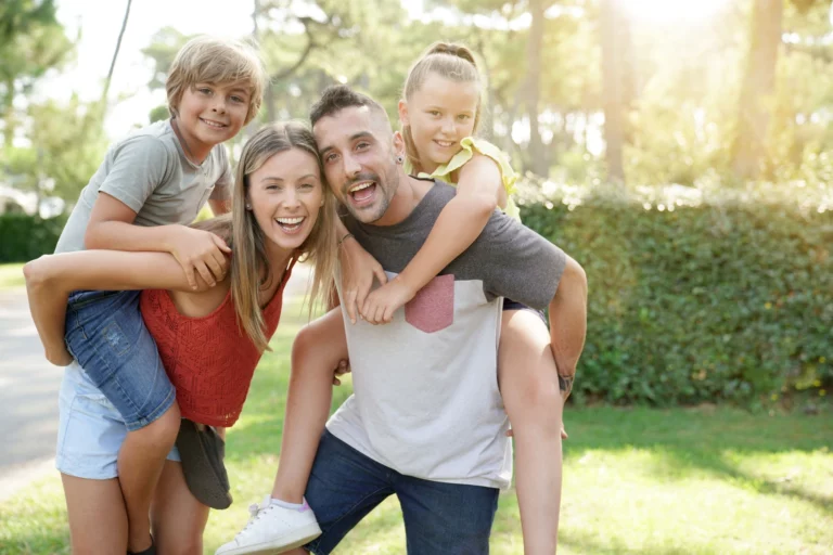 famille heureuse dans un camping les violettes ensoleillée à l'herbe verte